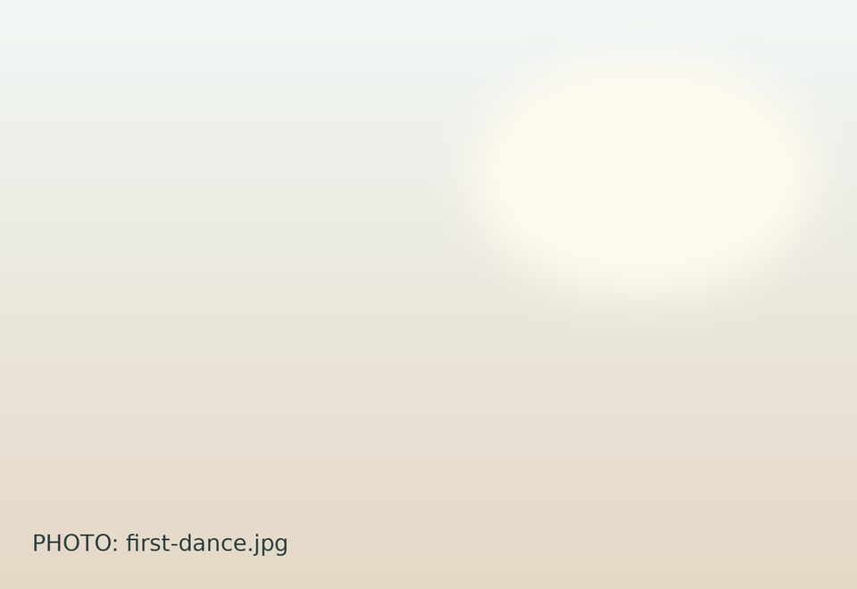 Newlyweds dancing beneath warm lights